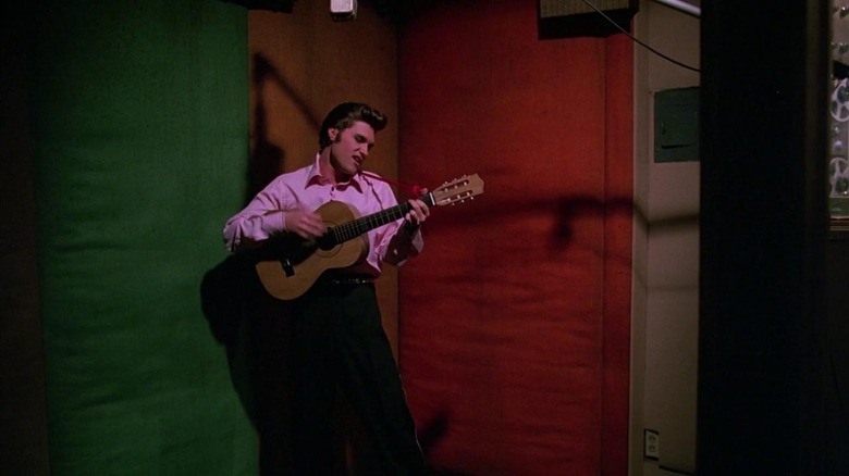 Elvis playing a guitar backstage in Elvis