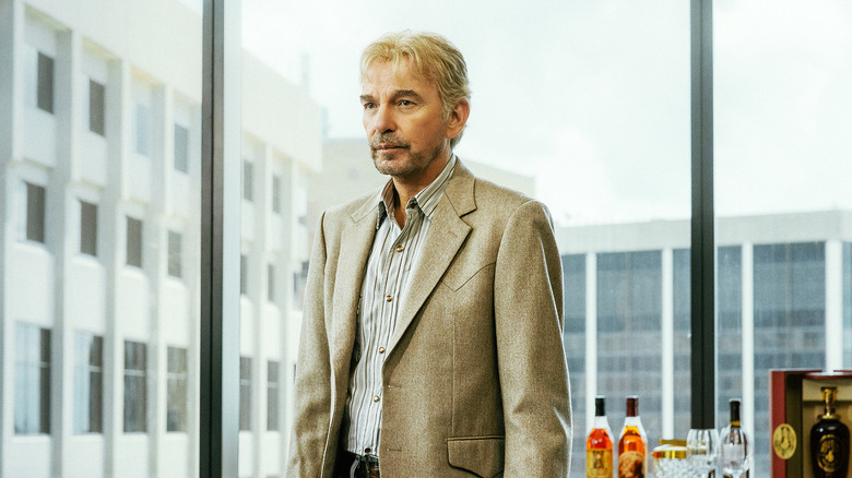 Billy Bob Thornton's Tommy Norris stands in an office by a window in Landman
