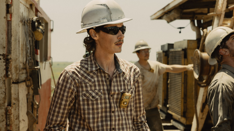 Jacob Lofland's Cooper Norris stands wearing a hard hat while out in the field in Landman