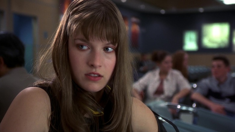 అలీ లార్టర్ యొక్క డార్సీ సియర్స్ ఫైనల్ డెస్టినేషన్‌లో విమానాశ్రయం గేట్ వద్ద కూర్చున్నప్పుడు ఆమె కుడివైపు చూస్తుంది