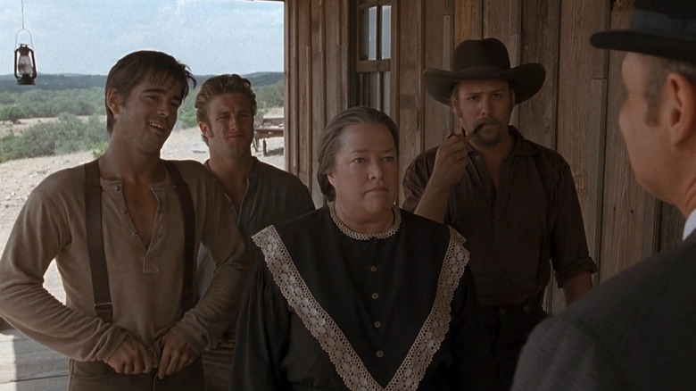 Jesse James (Colin Farrell) stands on a porch with Cole Younger (Scott Caan), Ma James (Kathy Bates), and Frank James (Gabriel Macht) in American Outlaws in American Outlaws