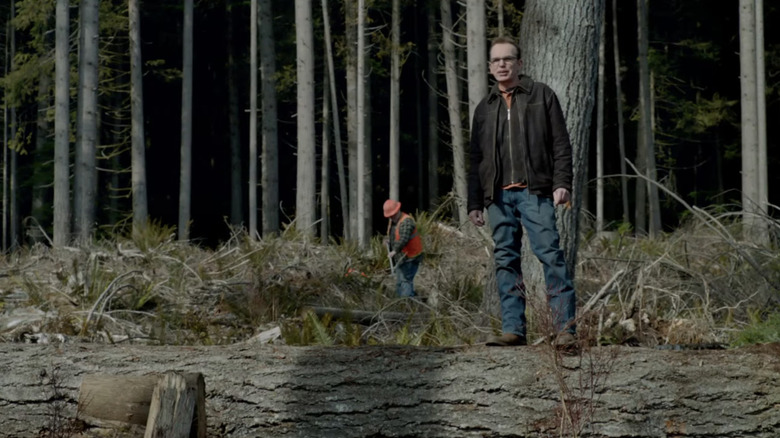 Billy Bob Thornton's Douglass stands on a log in Into the Grizzly Maze