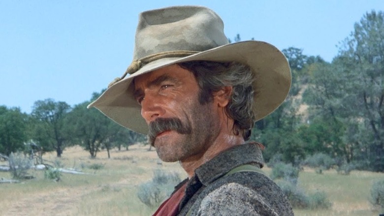 Sam Elliott as Dal Travern with his head cocked to the side in The Shadow Riders