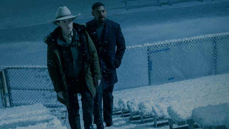 Kelly Macdonald's Kerry Kane walks through a snowy environment with Aaron Pierre's John Stewart in Lanterns