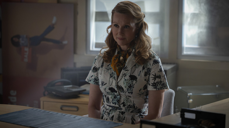 Laura Linney as an unnamed Guardian sitting behind a desk in Lanterns