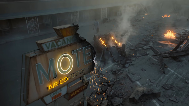 Aaron Pierre as John Stewart walking through the destroyed parking lot of a motel filled with fire and smoke in Lanterns