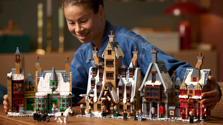 A woman looking at the LEGO Harry Potter Hogsmeade set