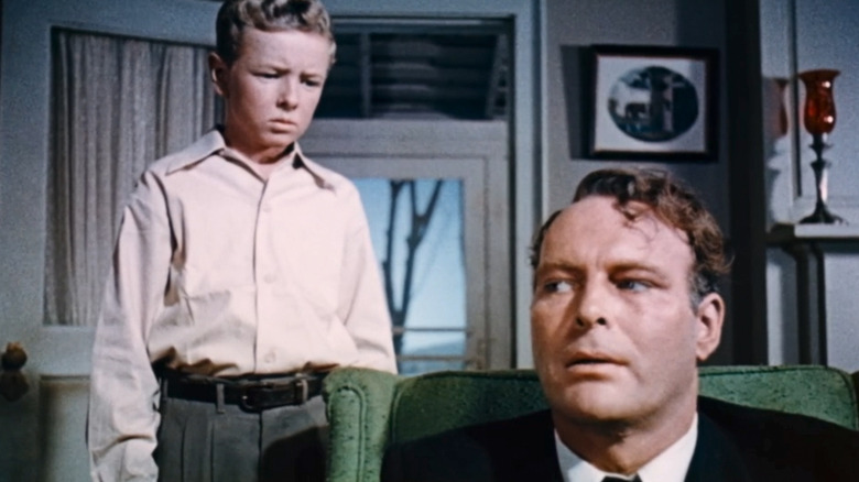 Jimmy Hunt's David MacLean stands behind Leif Erickson's George MacLean in a living room in Invaders from Mars