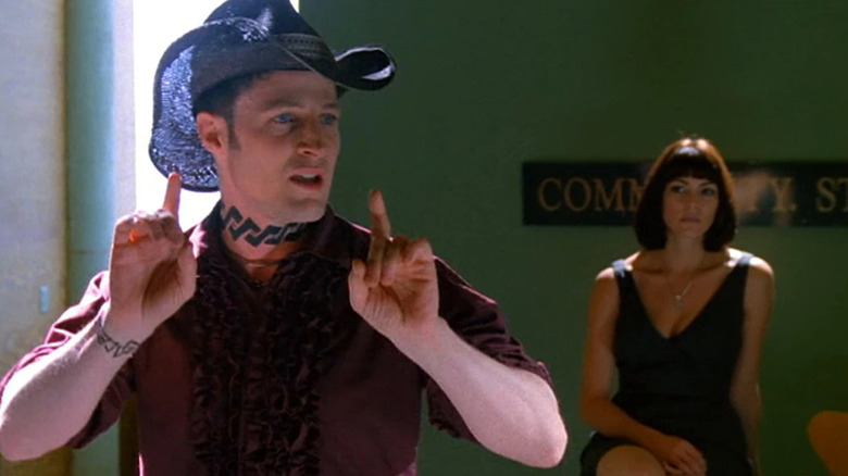 John in a cowboy hate in front of a slinky woman in Brave New World