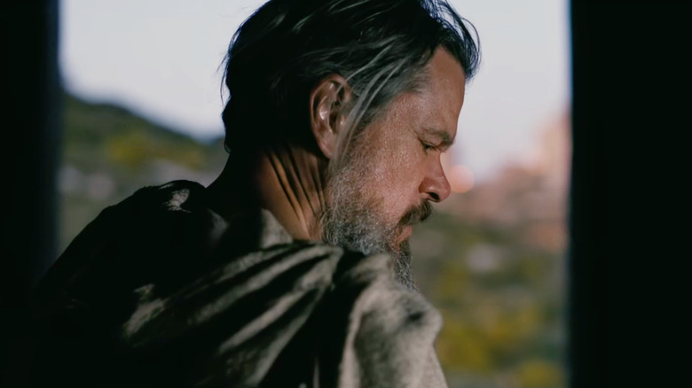 Matt Damon as Odysseus wearing a cloak while looking over his right shoulder in The Odyssey (2026)