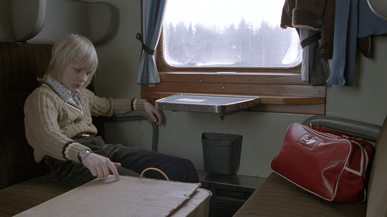 Oskar on a train in Let the Right One In