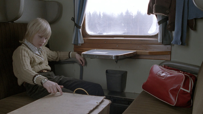 Oskar on a train in Let the Right One In