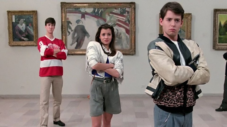 three kids standing in front of paintings with their arms crossed