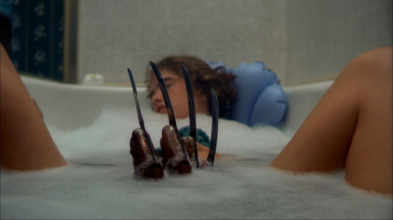 a woman sleeping in the bath and a hand with knives on the knuckles protruding from underwater