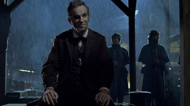 Lincoln (Daniel Day Lewis) smiles in the rain in Lincoln