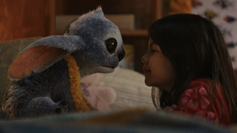 Stitch and Lilo sitting on the bed, face to face