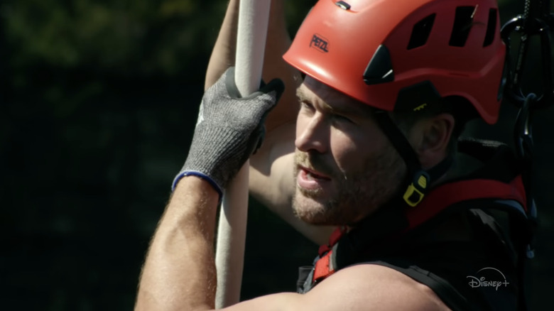 man in gloves and a red helmet holding onto a rope in close-up