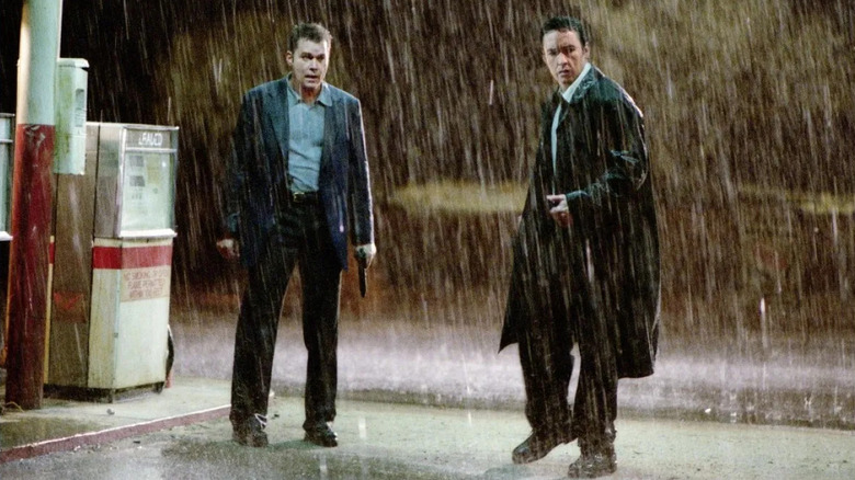 Samuel and Ed, guns drawn, at a rainy gas station in Identity