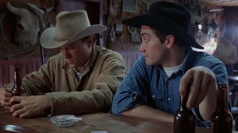 Heath Ledger as Ennis Del Mar sitting at a bar next to Jake Gyllenhaal as Jack Twist in Brokeback Mountain