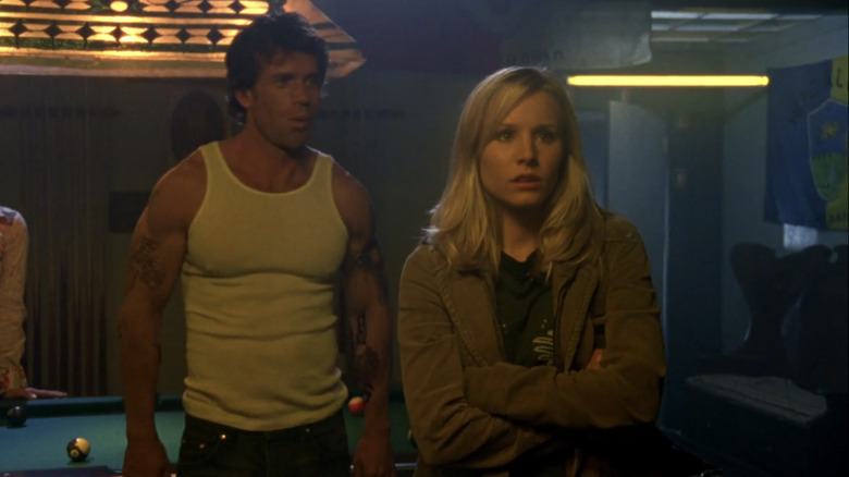 taylor Sheridan's Danny Boyd stands behind Kristen Bell's Veronica Mars in a bar in Veronica Mars
