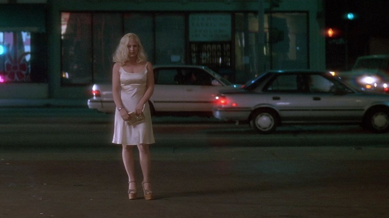 Alice, standing in the street in a white dress, a shot from Lost Highway.