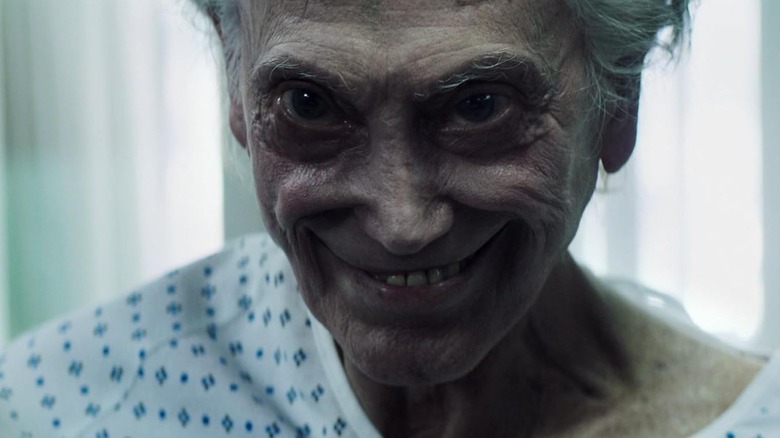 A demonically possessed corpse grinning wickedly in Truth or Dare