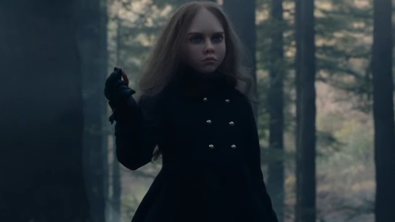 M3GAN woods holding ear