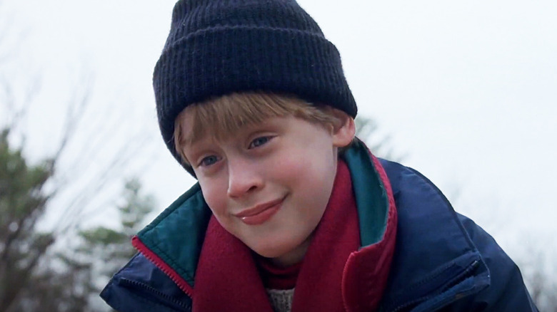Macaulay Culkin's Henry Evans smiles as he stands outside wearing winter clothes in The Good Son