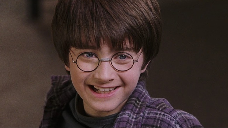 Daniel Radcliffee as Harry Potter smiling in Harry Potter and the Sorcerer's Stone
