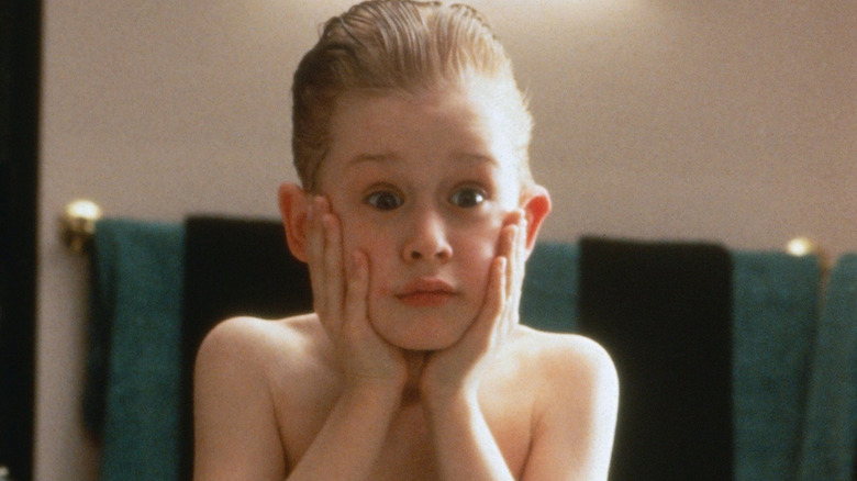 Macaulay Culkin as Kevin with his hands on his face in the mirror in Home Alone