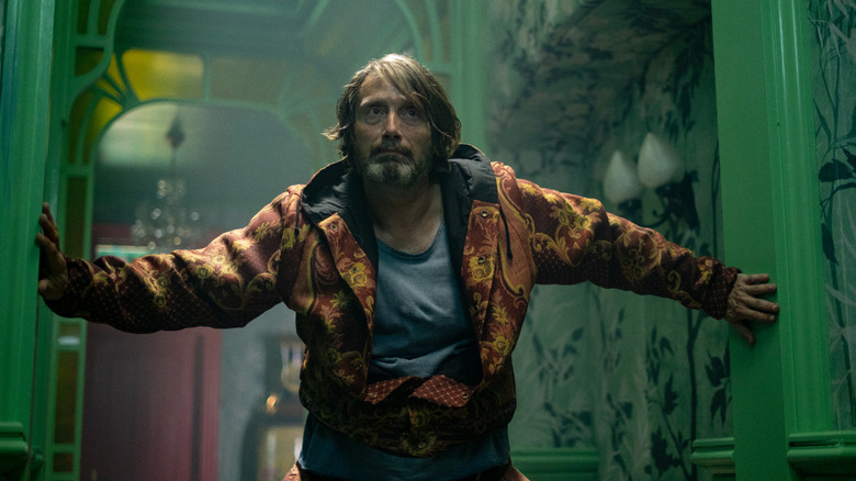 Mads Mikkelsen as a mysterious professional killer wearing a yellow and orange jacket in Dust Bunny