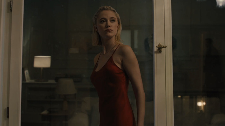 Maika Monroe's Julia stands by a window in Watcher