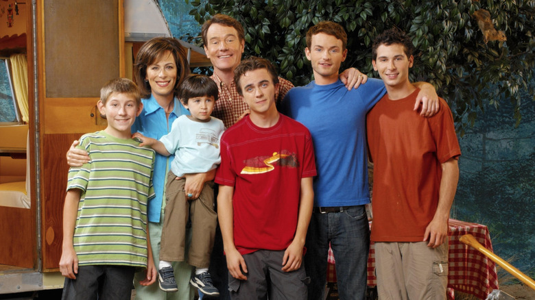 Erik Per Sullivan, Jane Kaczmarek, Bryan Cranston, Frankie Muniz, Christopher Masterson, Justin Berfield, and Lucas Rodriguez as the Wilkerson family on a campsite in a promotional image for Malcolm in the Middle