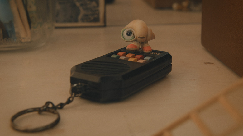 marcel the shell standing on a keychain remote