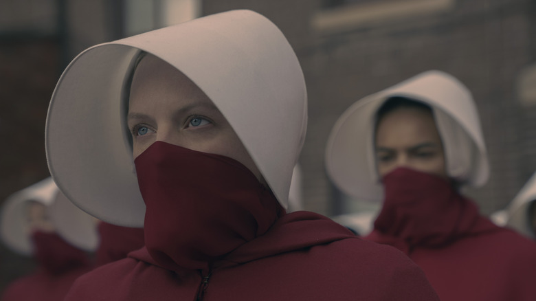 Offred/June wearing her Handmaid outfit and a mask in The Handmaid's Tale