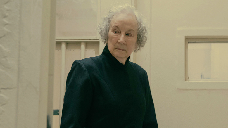 Margaret Atwood's prison guard looking to the side in The Testaments