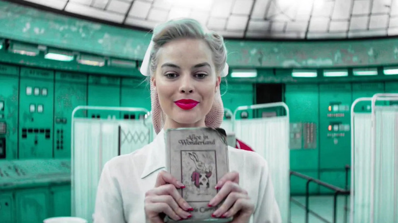 Margot Robbie dressed as a vintage nurse holding a copy of Alice in Wonderland in Terminal