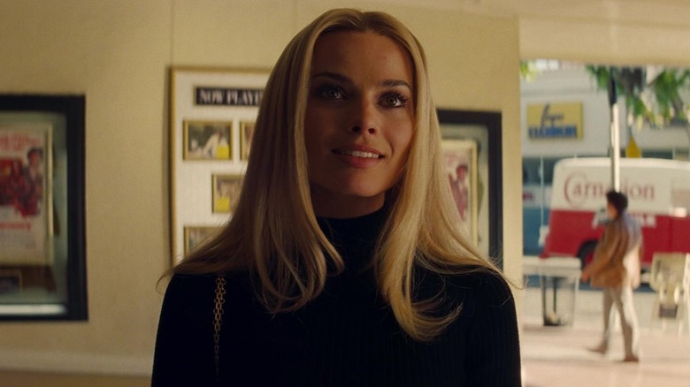 Margot Robbie as Sharon Tate smiling outside of the movie theater in Once Upon a Time in Hollywood