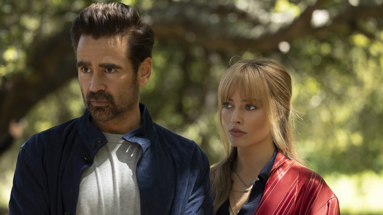 Colin Farrell as David standing next to Margot Robbie as Sarah with a serious look on his face in A Big Bold Beautiful Journey