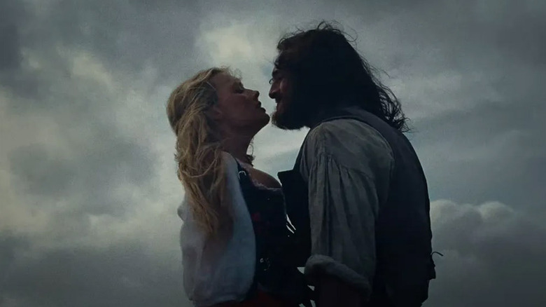 Catherine and Heathcliff about to kiss amidst storm clouds in Wuthering Heights