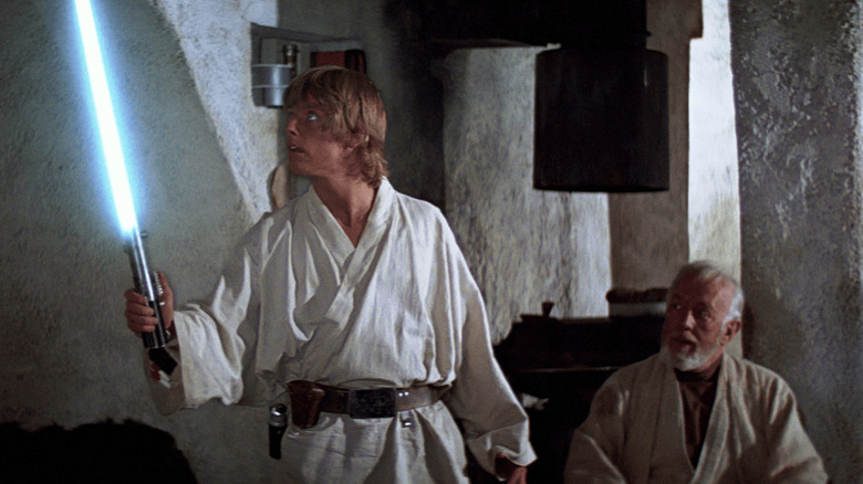 Mark Hamill holding lightsaber and Alec Guinness in Star Wars: A New Hope