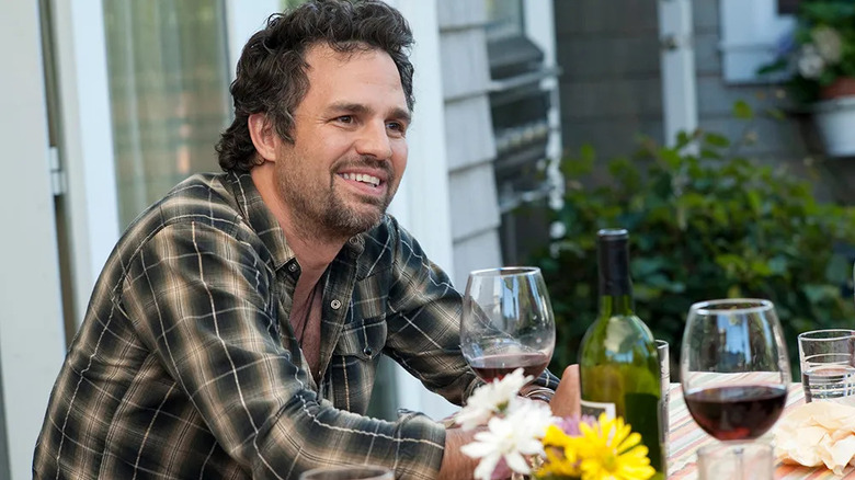 Paul Hatfield (Mark Ruffalo) smiles at a table with wine in The Kids Are All Right