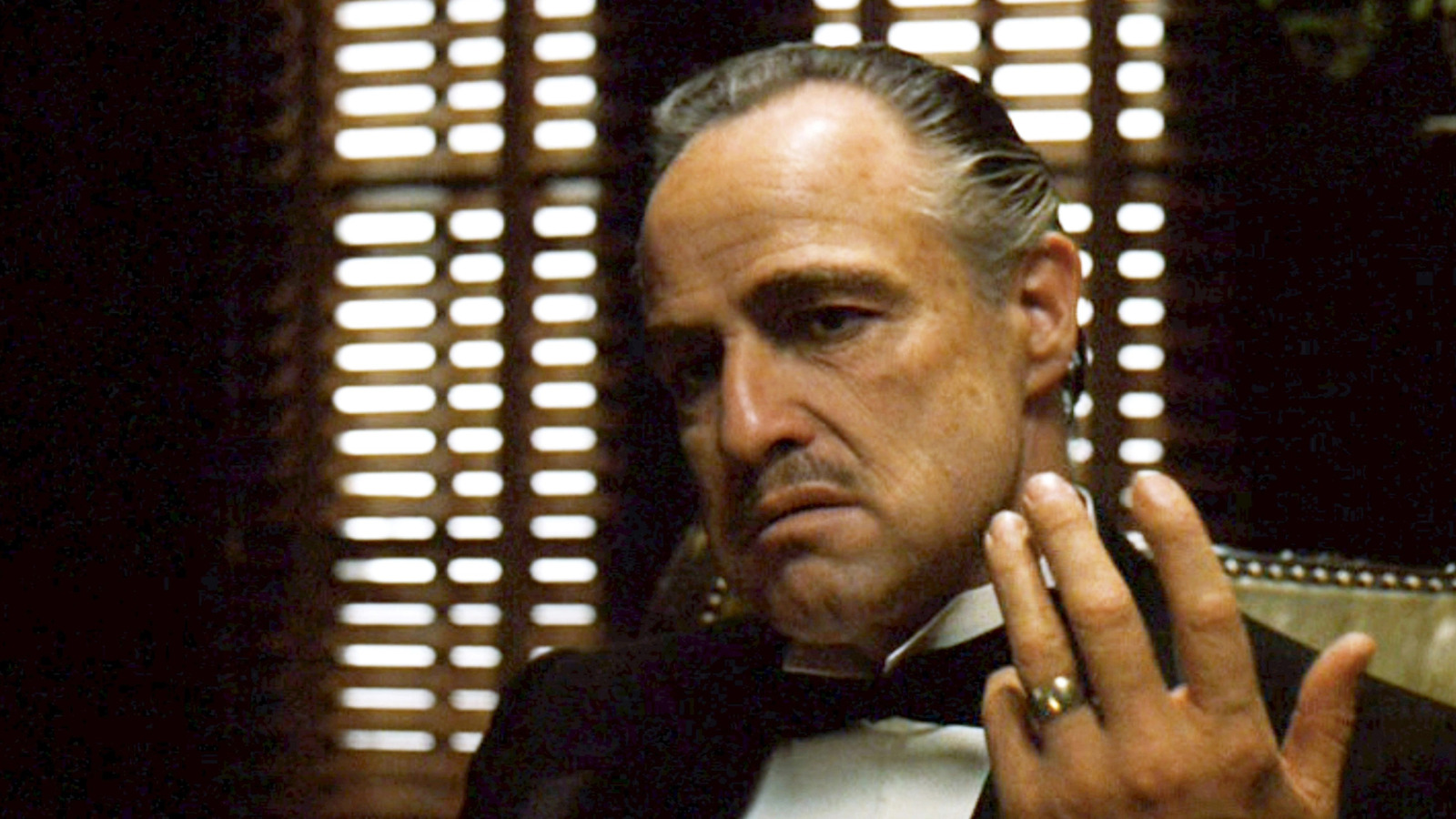 Vito Corleone hátrasimított hajjal a Keresztapából. 
