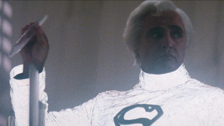 Marlon Brando's Jor-El holds a crystal while wearing a white suit in Superman