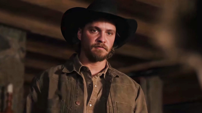 Luke Grimes' Kayce Dutton stands in his cabin in Marshals