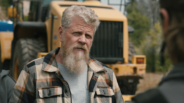 Michael Cudlitz's Randall Clegg is seen over the shoulder of Luke Grimes' Kayce Dutton as they stand outside in Marshals.jpg