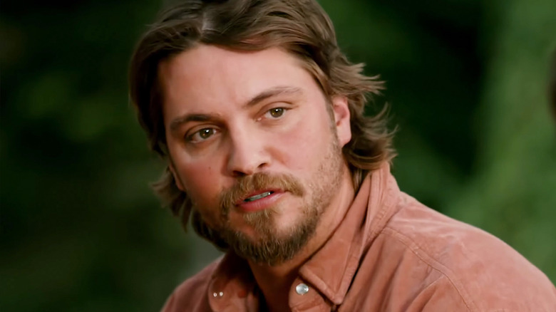 Kayce Dutton de Luke Grimes regarde à travers le cadre sur un fond vert flou dans Marshals