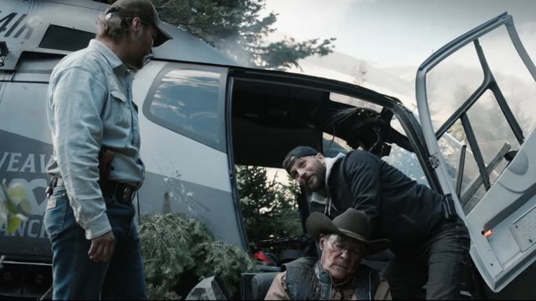 Luke Grimes' Kayce Dutton watches as Logan Marshall-Green tends to Chris Mulkey's Tom Weaver next to a downed helicopter in Marshals