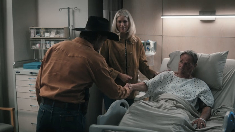 Luke Grimes' Kayce Dutton shakes the hand of Chris Mulkey's Tom Weaver as Ellyn Jameson's Dolly Weaver watches in a hospital room in Marshals