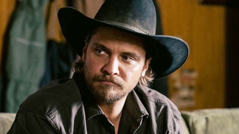Luke Grimes' Kayce Dutton looks off to his right as he sits in a cabin in Marshals